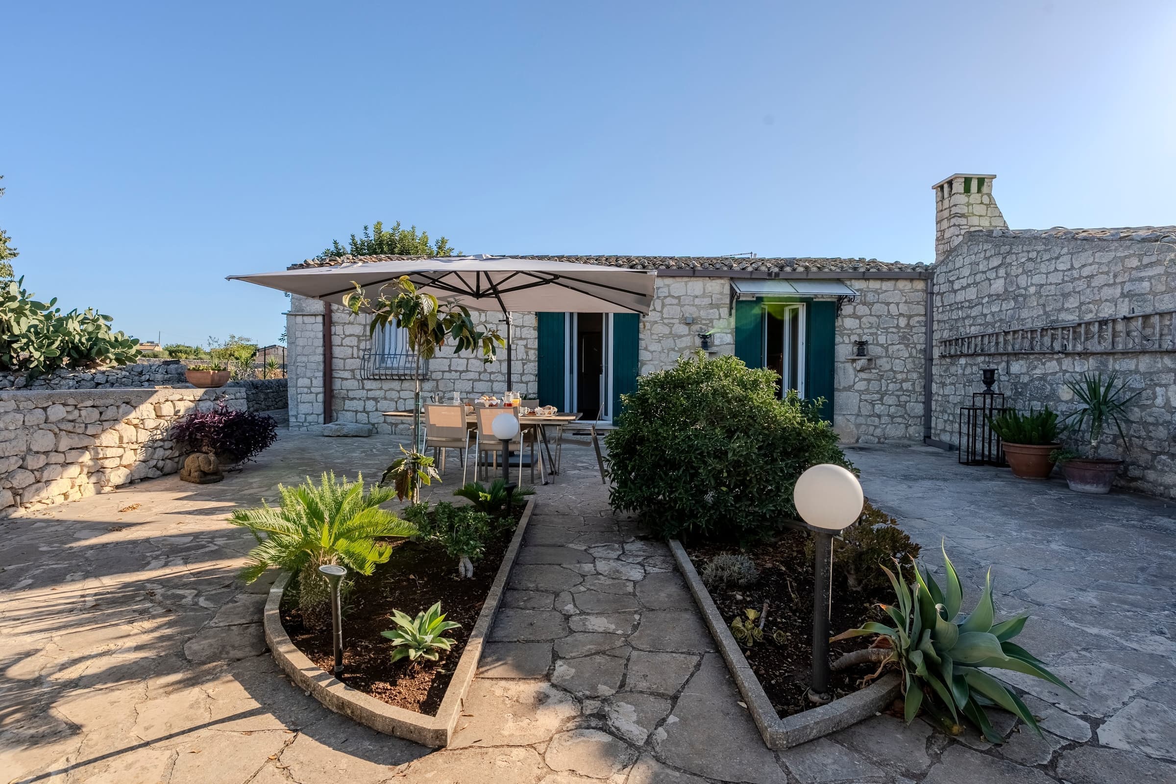 Sunlit entrance courtyard with traditional stone architecture